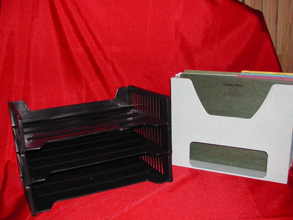 3 black stackable plastic trays for filing and a white desktopper holding file folders for filing paperwork