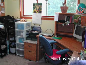 A home office with a clear desk , filing cabinet and rolling drawers 