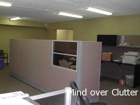 An office cubicle with beige room divider and u-shaped desk 