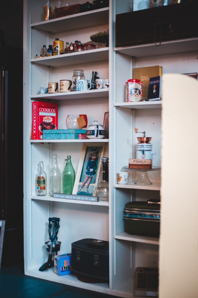 White shelves with books and home decor items. 