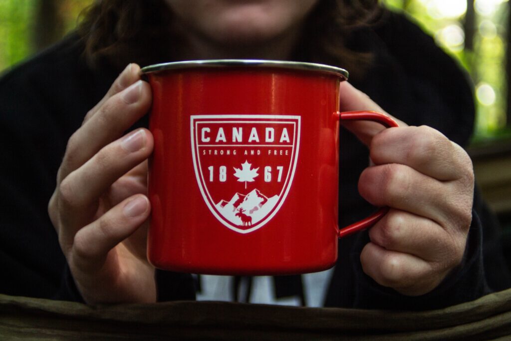 A red mug with a Canada logo containing 1867 and a maple leaf