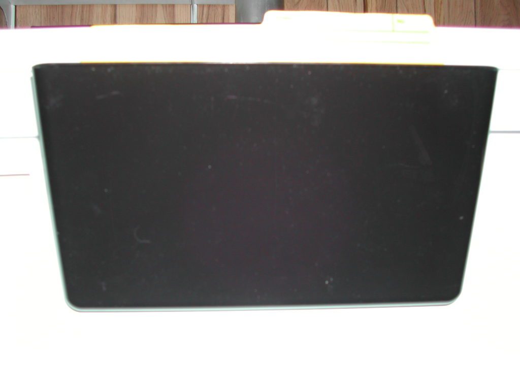 black plastic file holder magnetically attached to a fridge 
