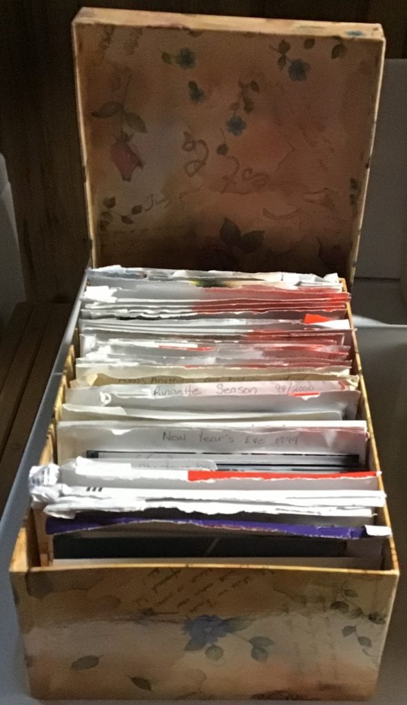 A photo box containing envelopes with sets of pictures in each envelope relating to a theme.