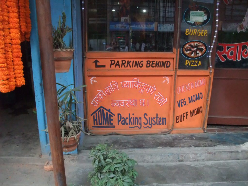 An orange sign with the word home with a roof drawn over it. 