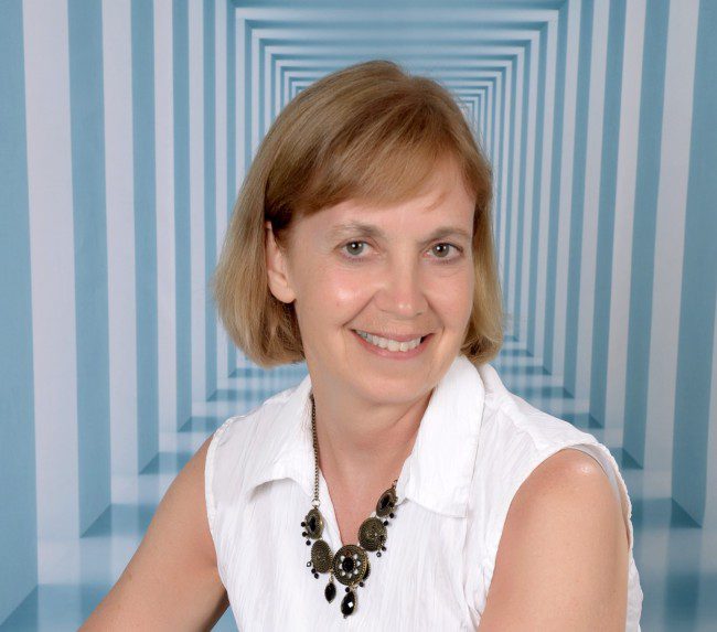 A head shot of Julie Stobbe with a blue and white striped background.