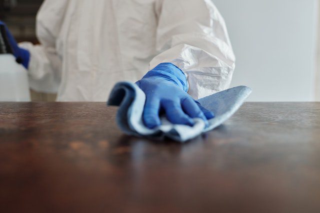 Person wiping a wooden surface