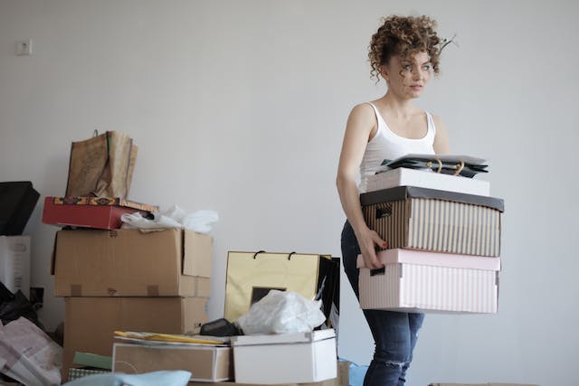 A woman holding a stack of boxes