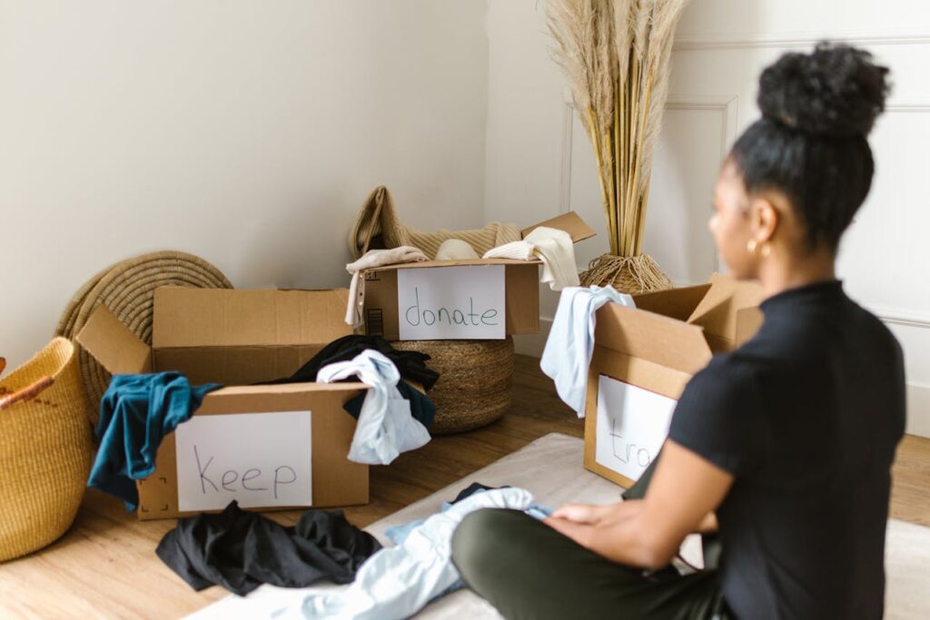 A woman on the floor with boxes labeled “Keep” and “Donate.”