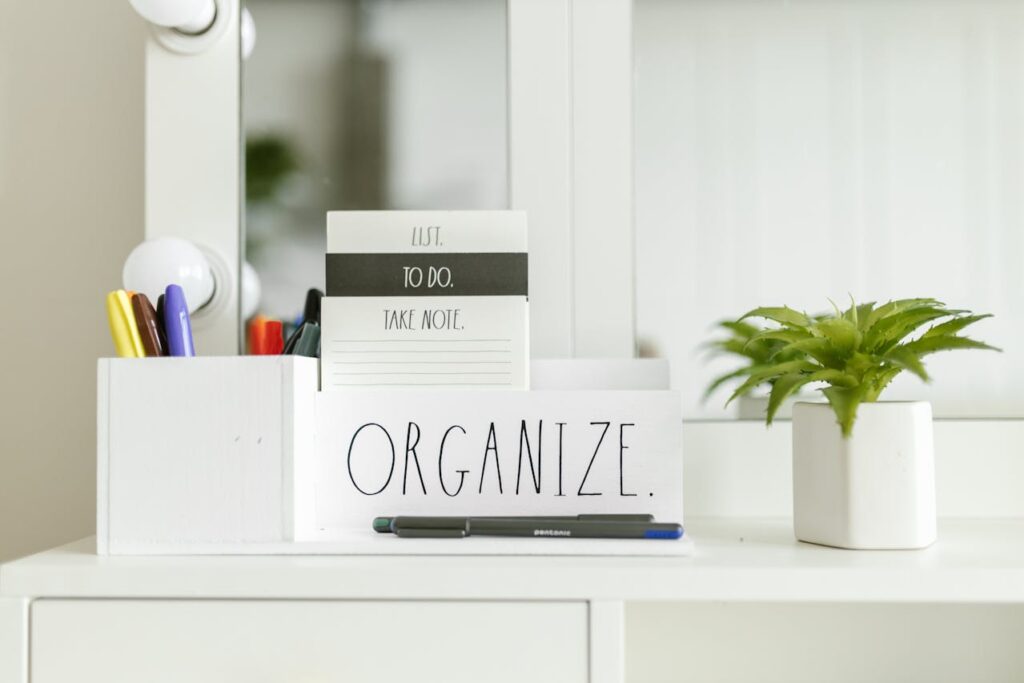 An “organize” sign next to a plant and a pen holder