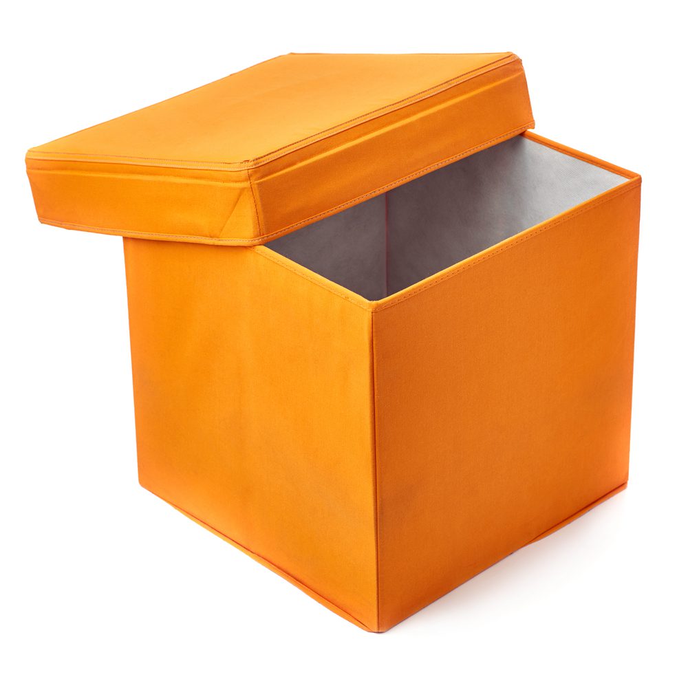 An orange ottoman to sit on and use for storage.