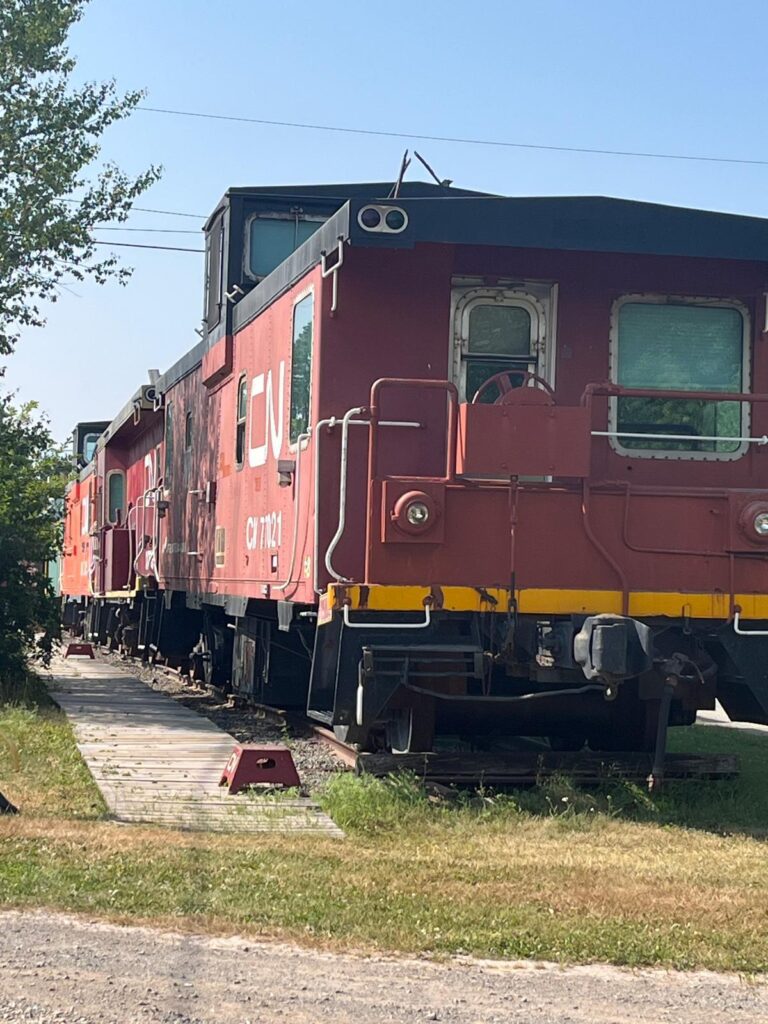 A line of caboosses on a train track that is a hotel. 