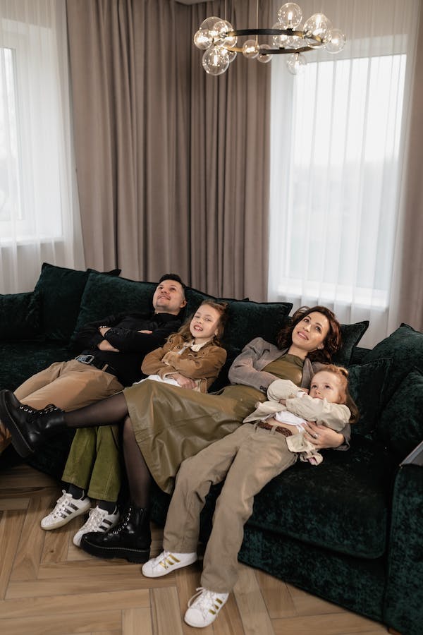 Four members of a faimily slouching on a couch looking tired